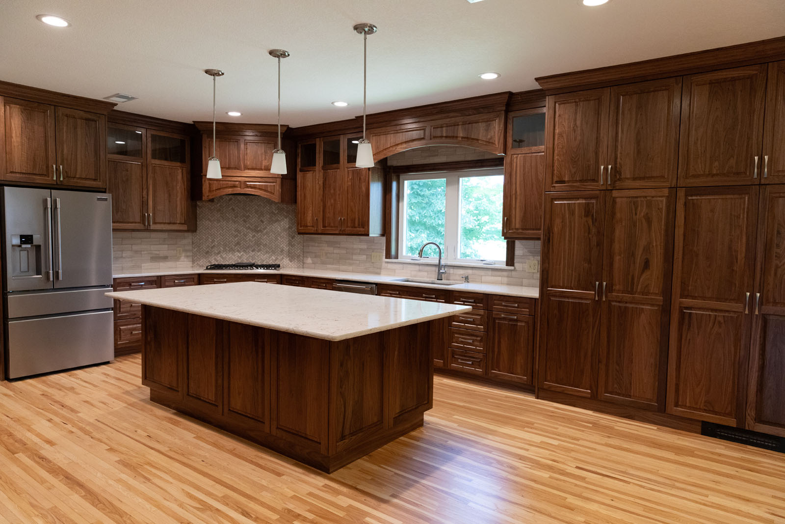 Custom cream-painted kitchen with brass hardware and oak accents in a Rochester, MN home